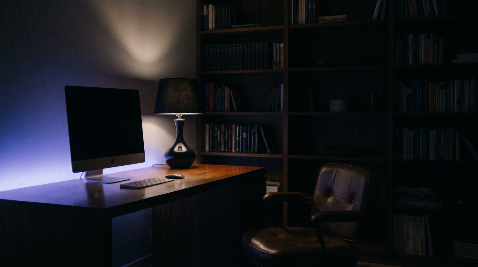 Spokojne domowe biuro nocą z dyskretnie podświetlonym monitorem